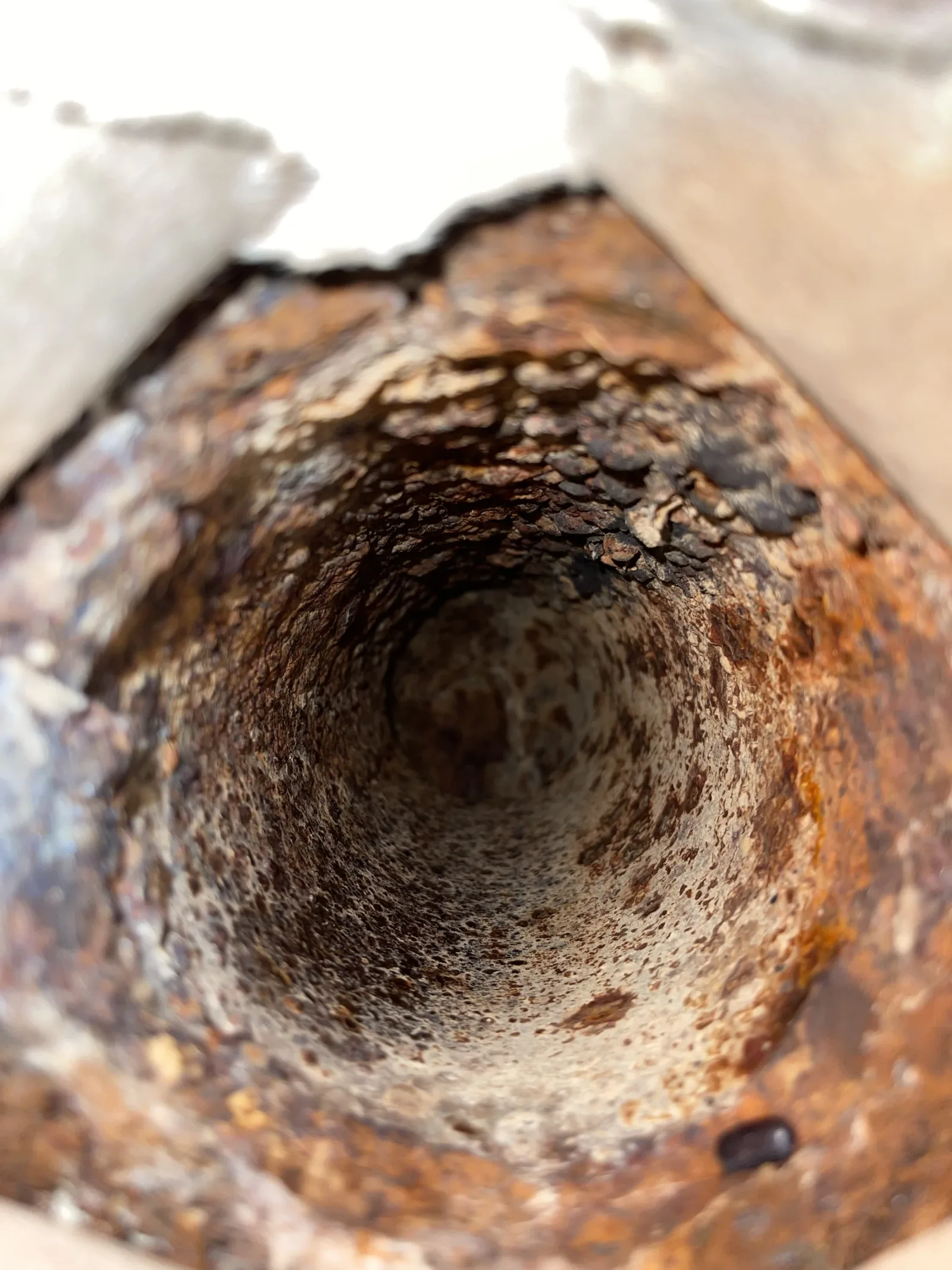 Close view inside a severely deteriorated cast-iron drain pipe
