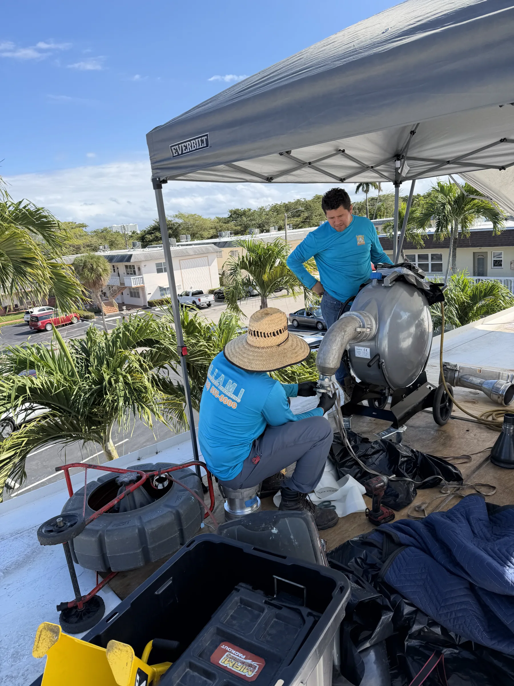 Miami Trenchless technicians operating specialized liner equipment during a rooftop project